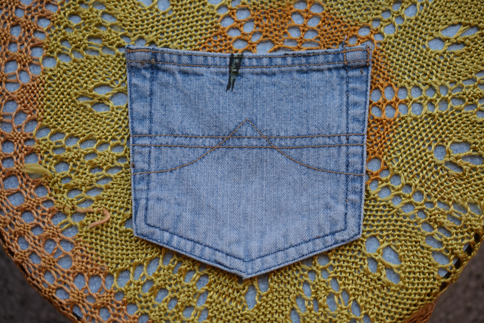 Denim jeans pocket on a yellow knitted background
