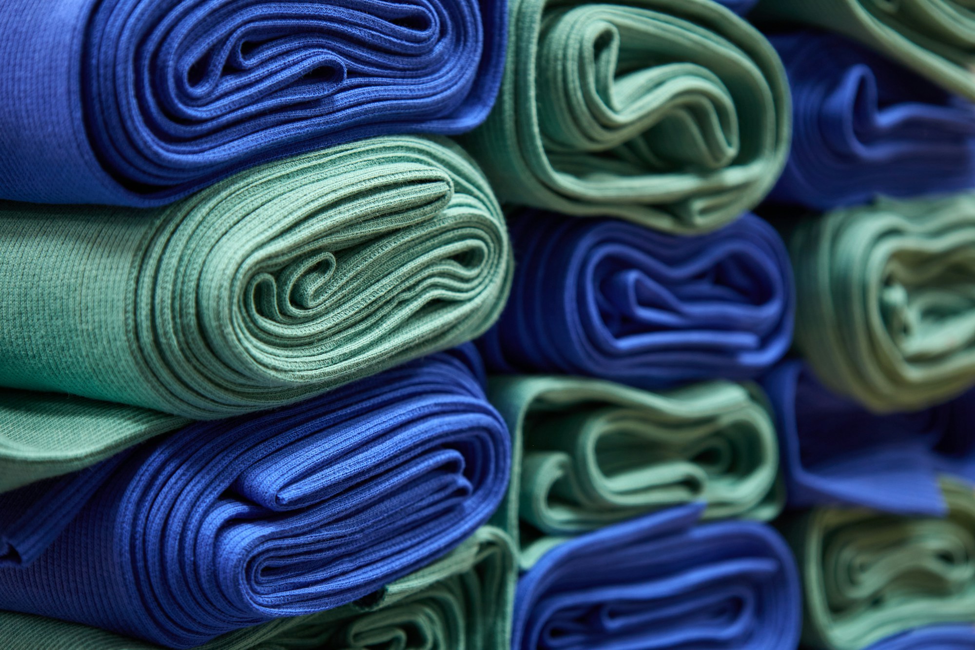 Stack of soft folded fleece in blue and green for a no-sew blanket gift