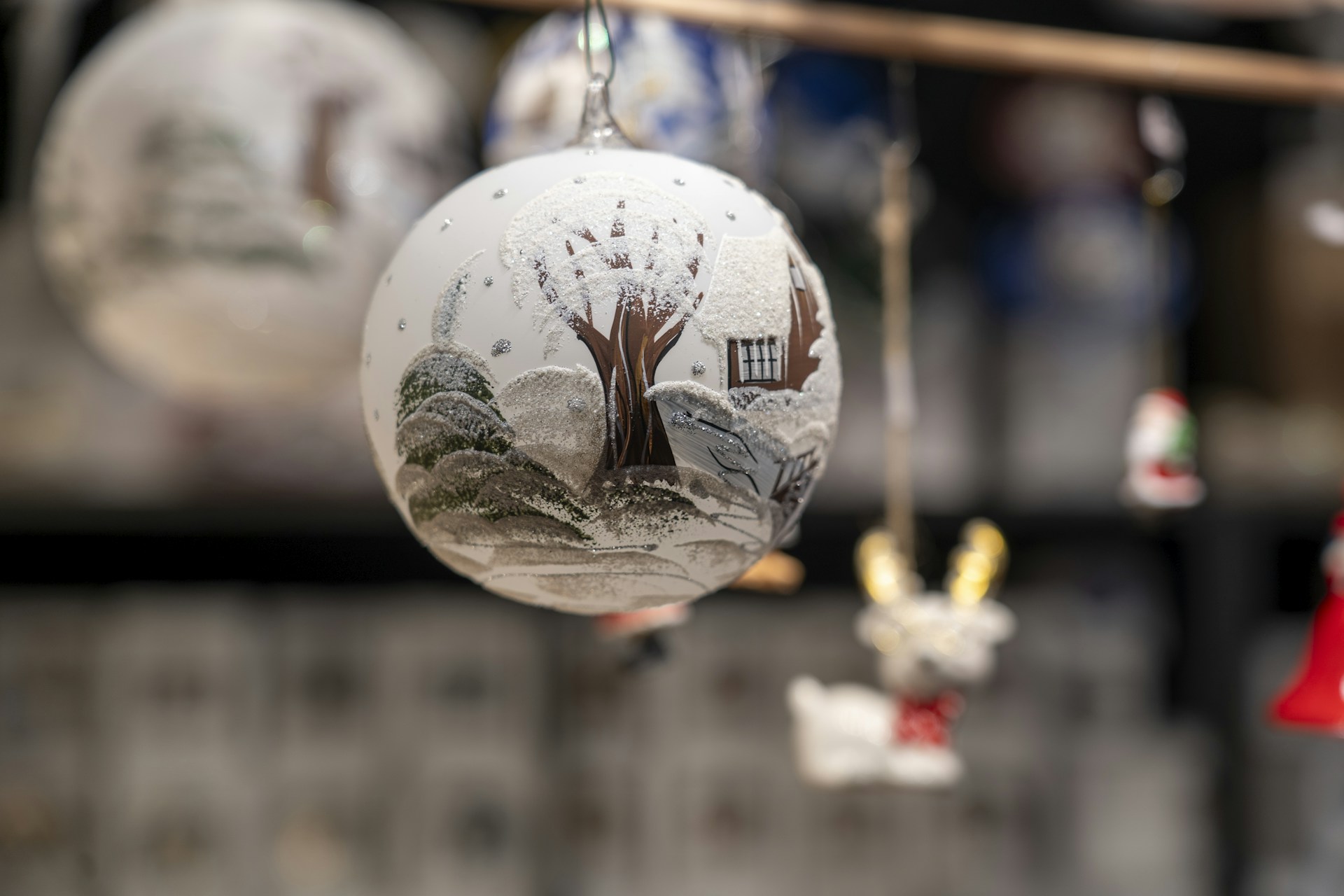 Hand painted ornaments with a frosted winter tree on a pale glass ball