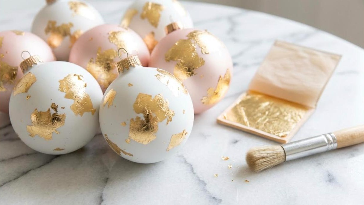 Gold leaf ornament makeovers in matte white and blush with a booklet of gold leaf and a soft brush