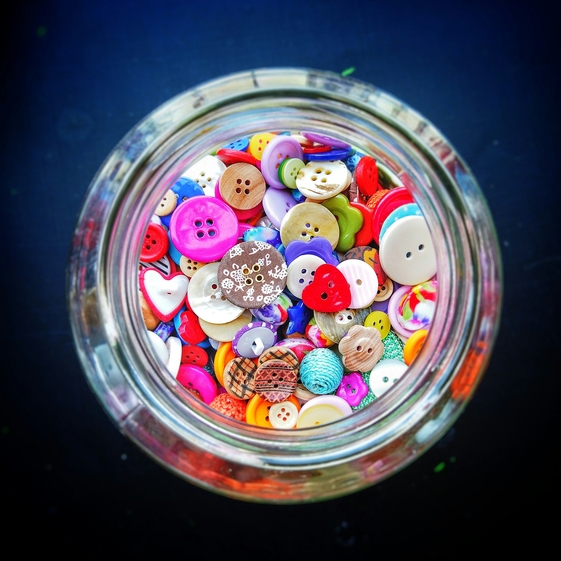 Old school household hacks jar full of colorful sewing buttons