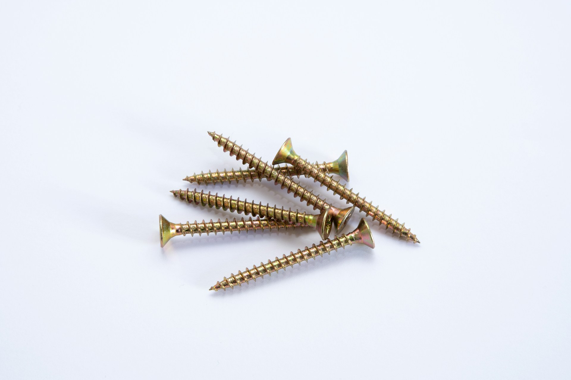 Loose brass screws on a white table