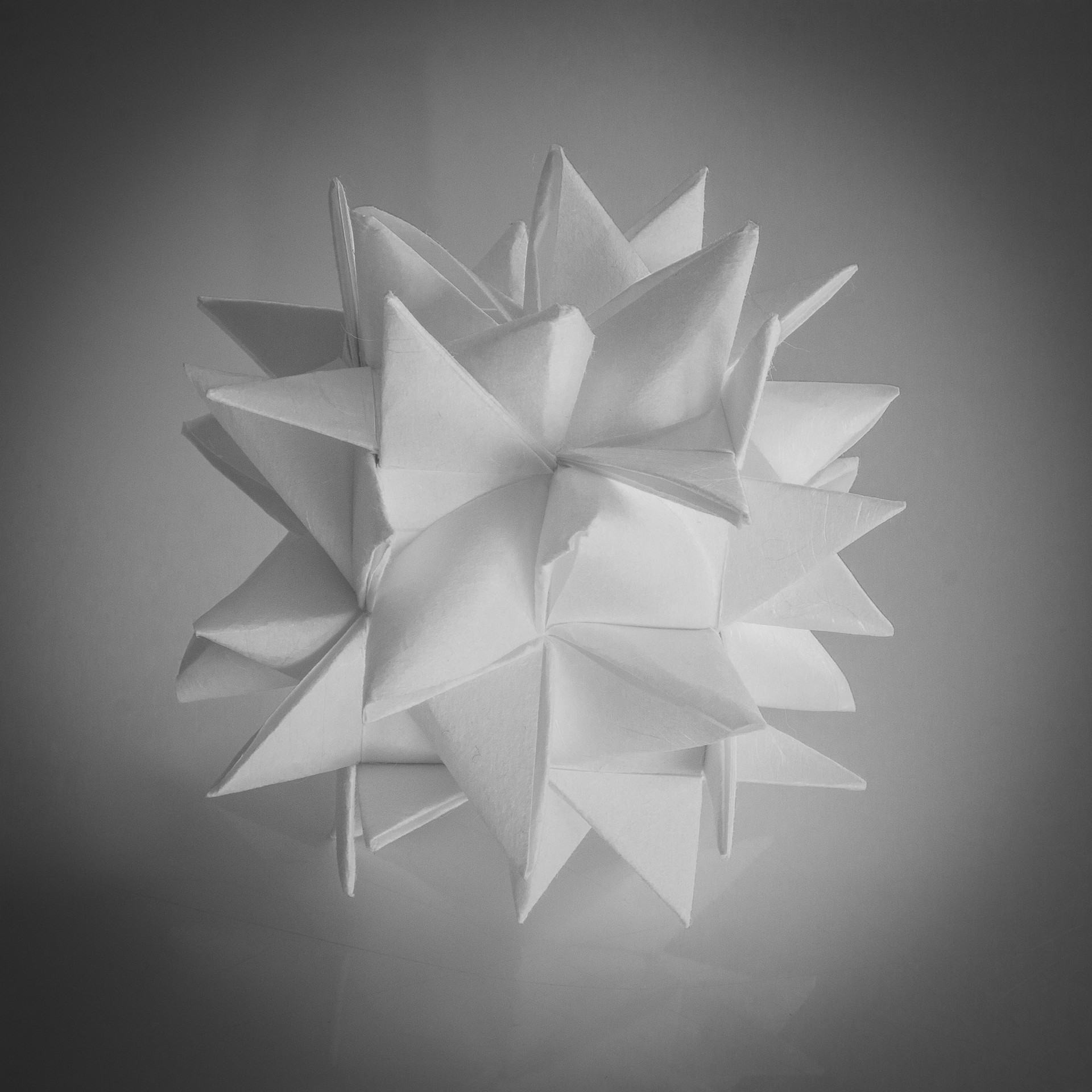 Folded white paper star ornament with sharp three dimensional points