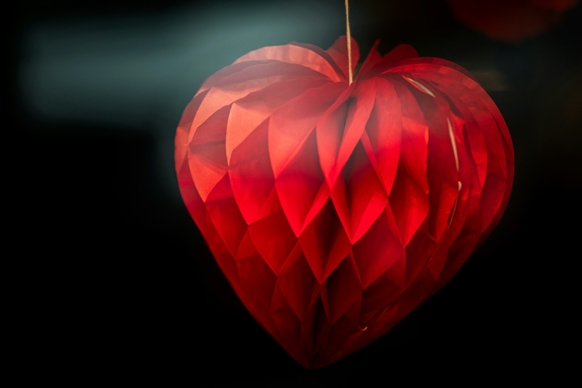 Hans Christian Andersen inspired red honeycomb paper heart decoration glowing in a window
