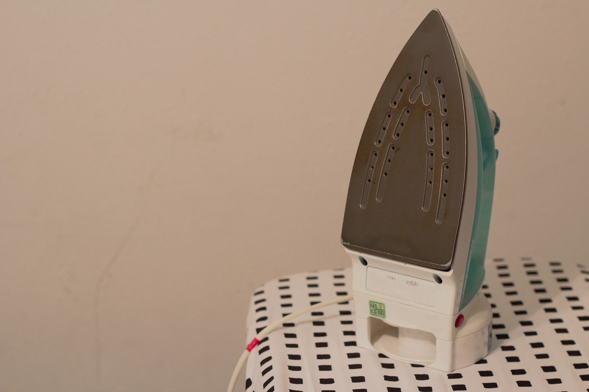 Clothes iron standing on an ironing board