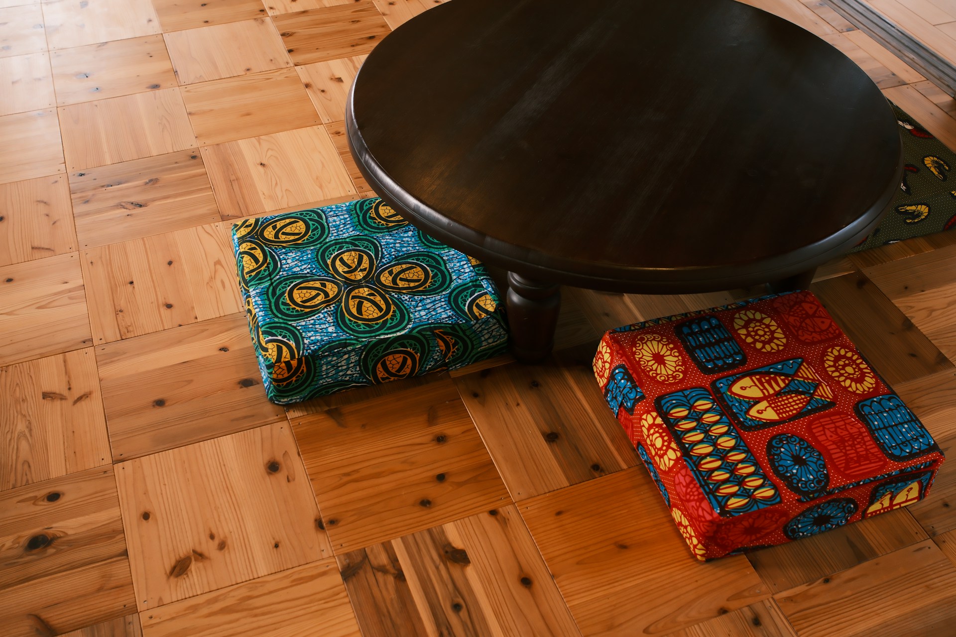 Japanese Winter Hacks colorful square floor cushions under a dark low round table