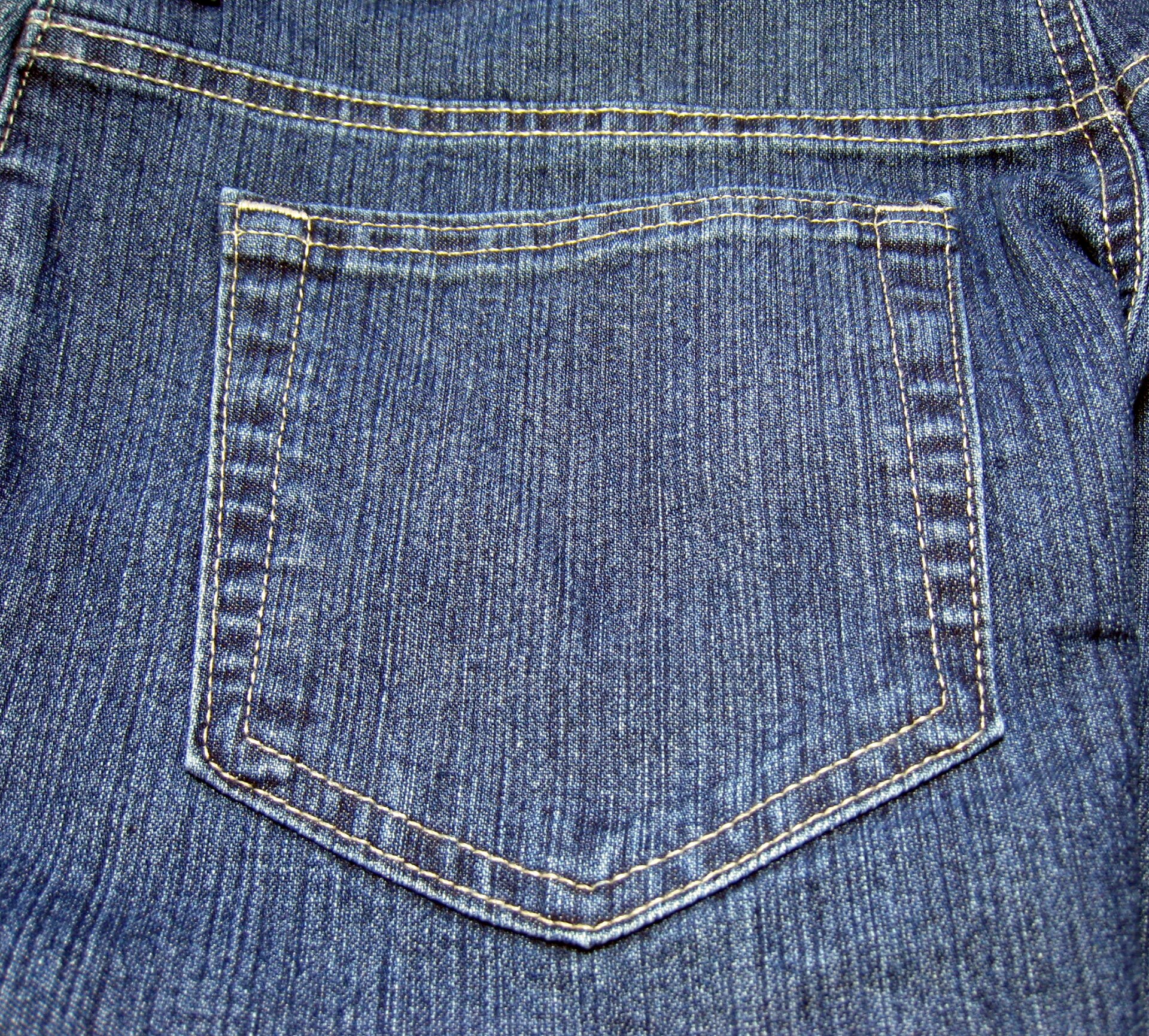 Close-up of a back pocket on old blue jeans