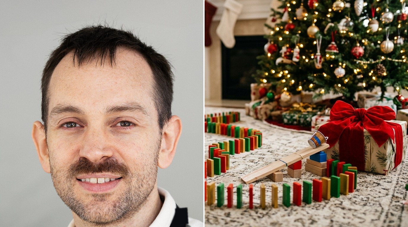 Joseph Herscher beside a homemade domino and ramp gift machine leading to a wrapped present under a Christmas tree