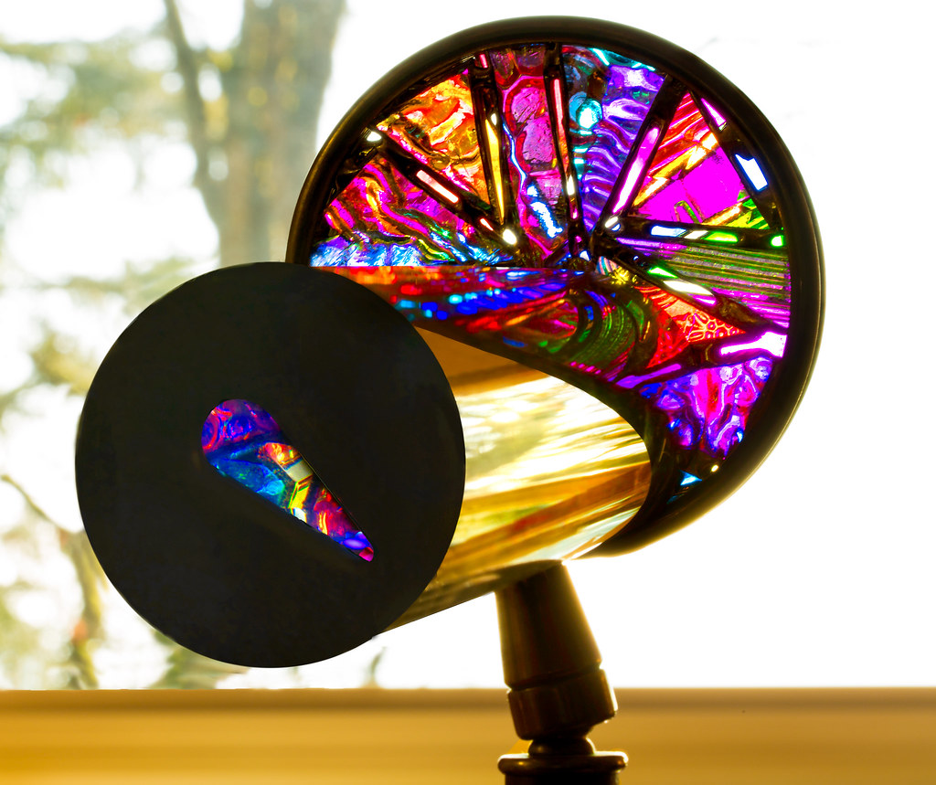 Handmade kaleidoscope with a colorful stained glass style end on a stand