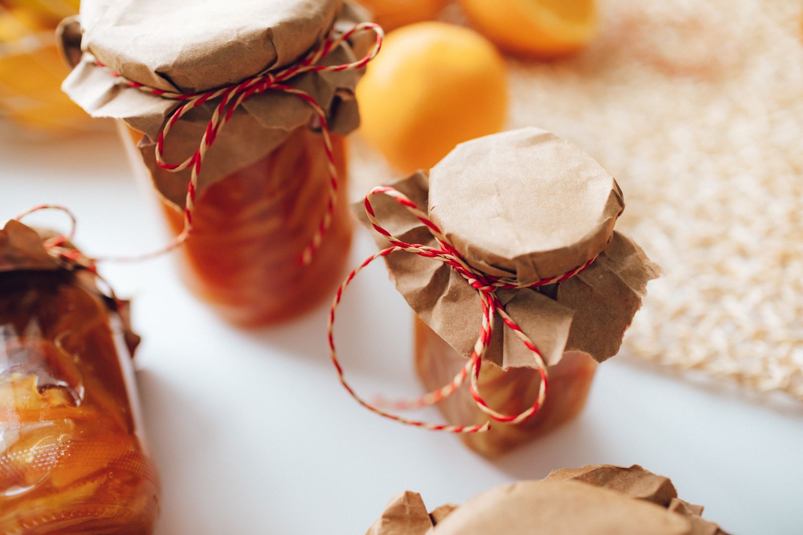 Homemade jam jars topped with brown paper and red and white twine