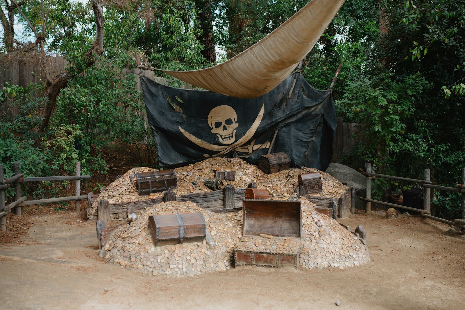 Pirate flag hanging over wooden treasure chests on a pile of hay