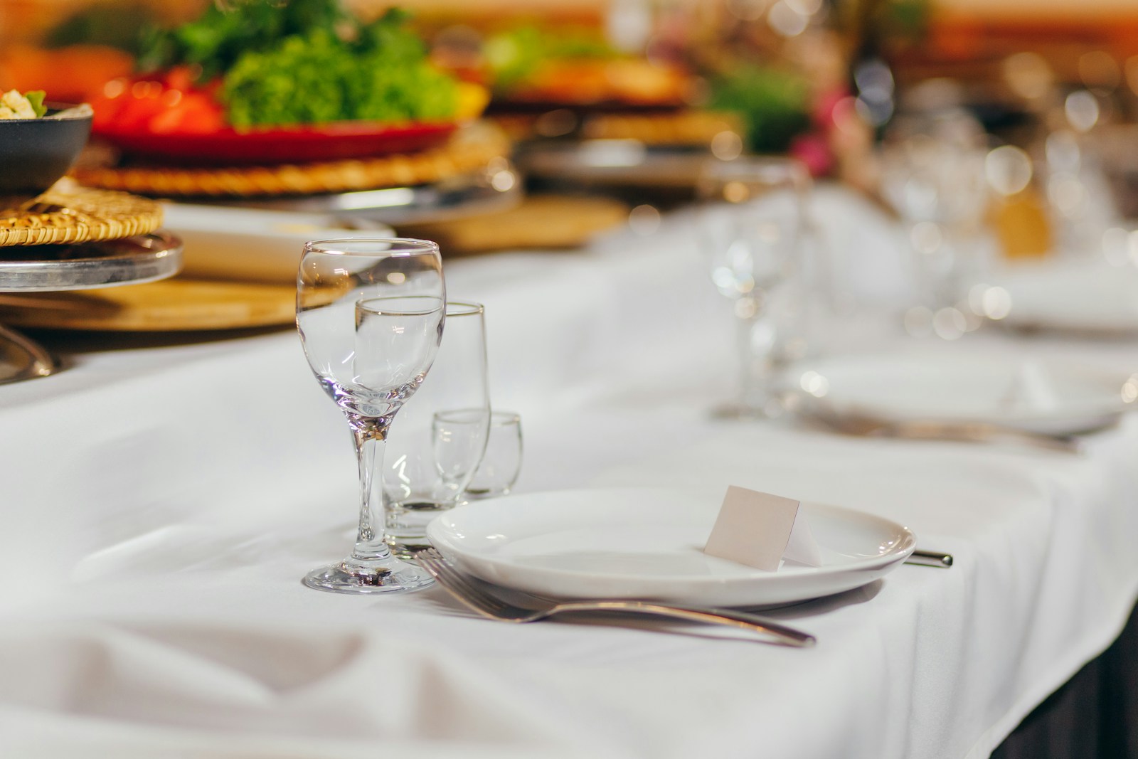 Long dining table with a white tablecloth set for a dinner party