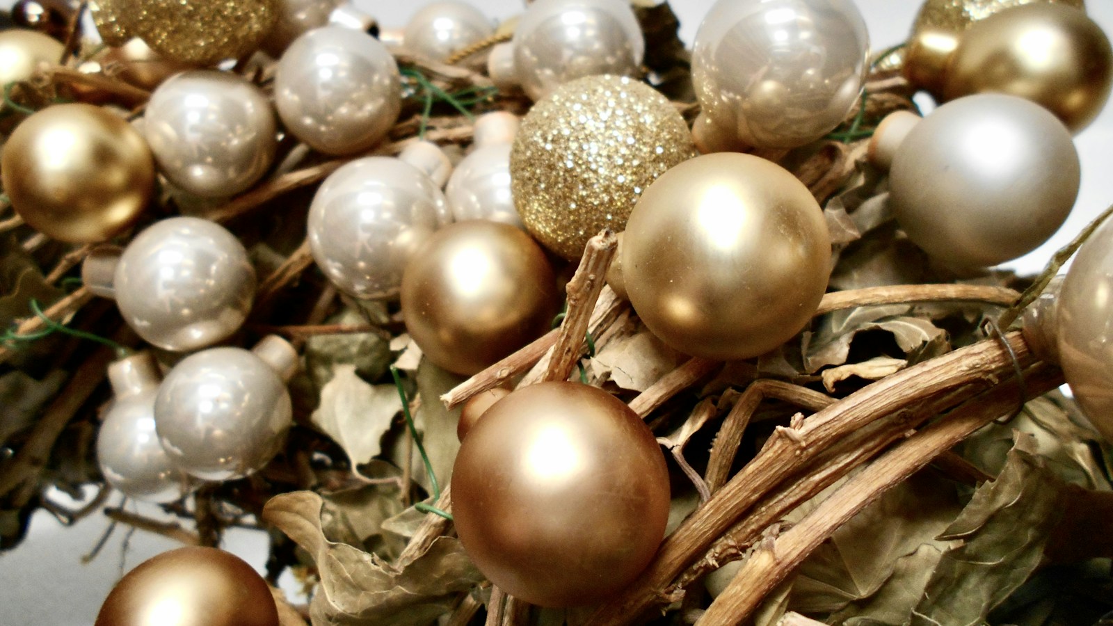 A cluster of gold, champagne and silver ornaments mixed together for a designer look