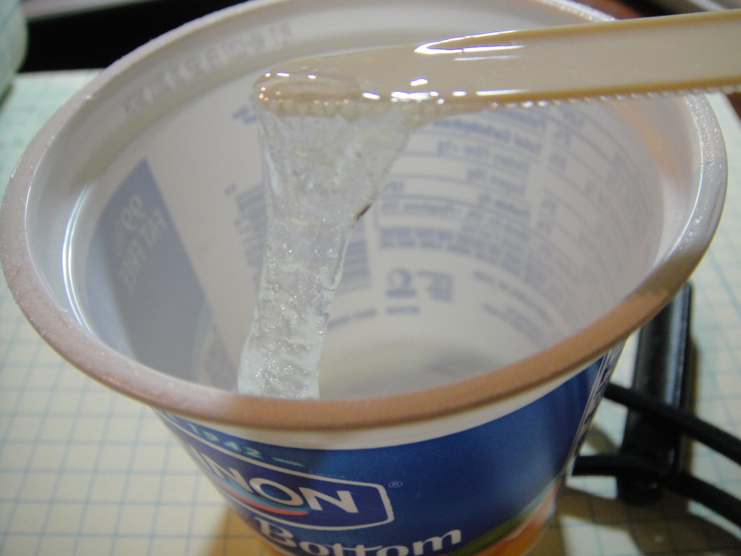 Clear epoxy resin and hardener being mixed in a plastic cup