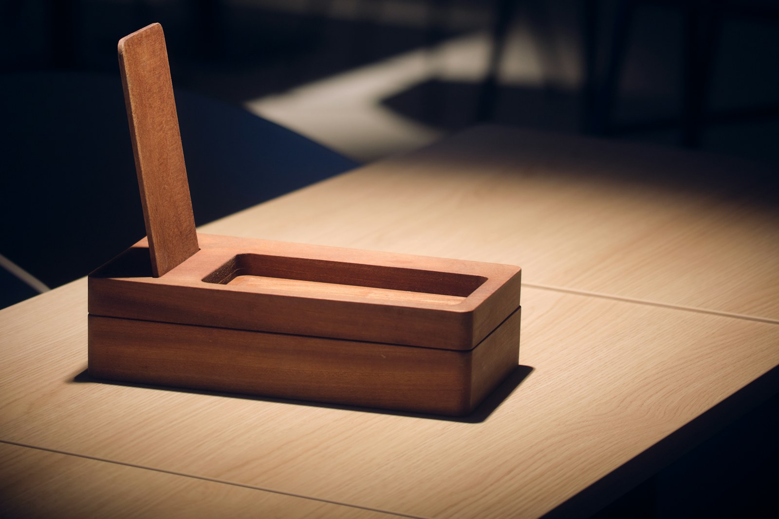 A small handmade wooden box with its lid lifted on a table