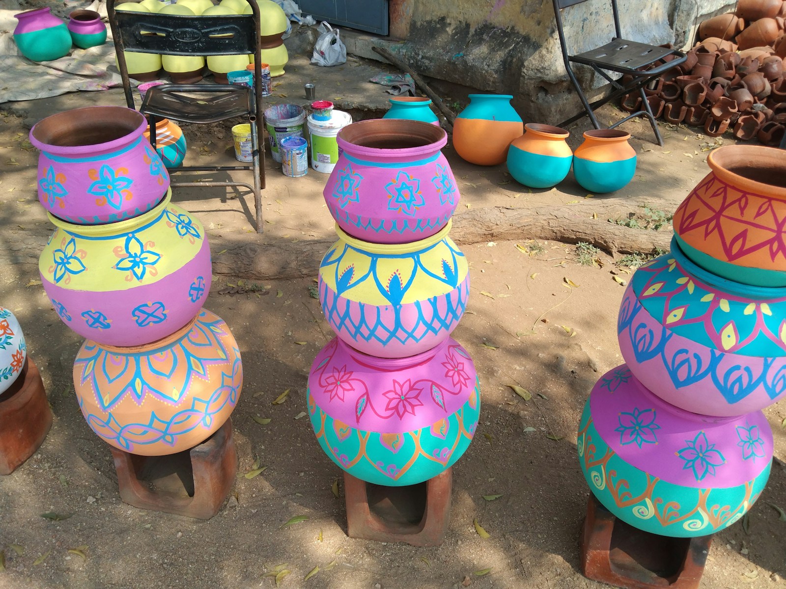 Colorful painted pots stacked outdoors