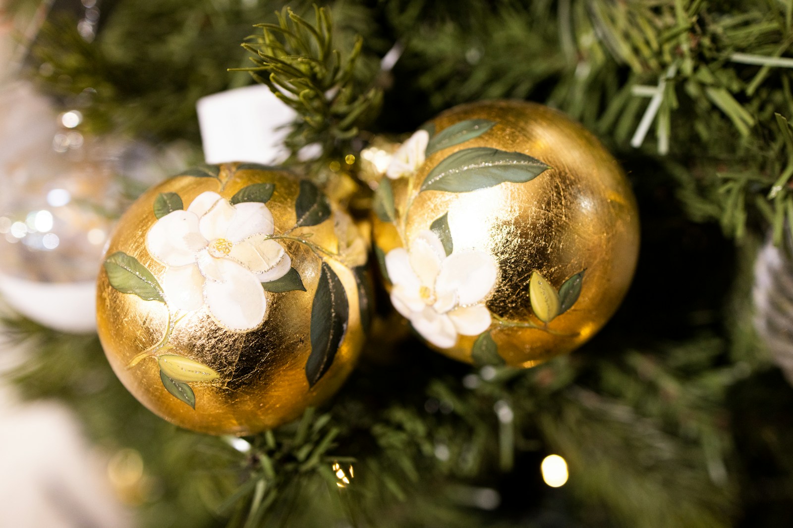 Napkin decoupage ideas inspiration: two gold ornaments with white flower designs on a tree