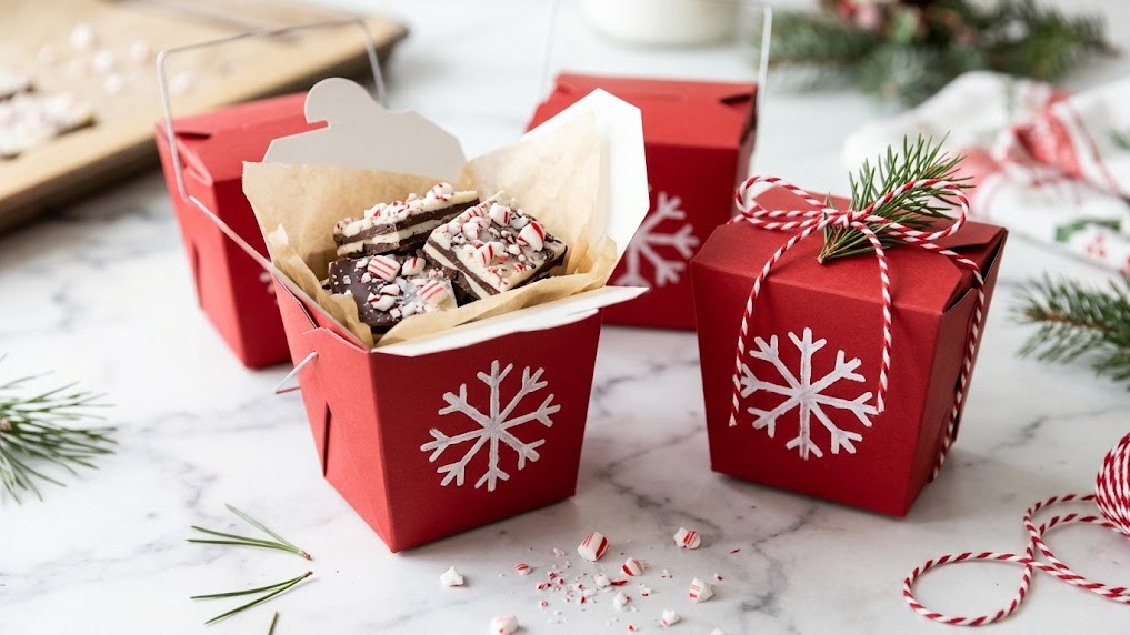 Peppermint bark in a red takeout box with a ribbon