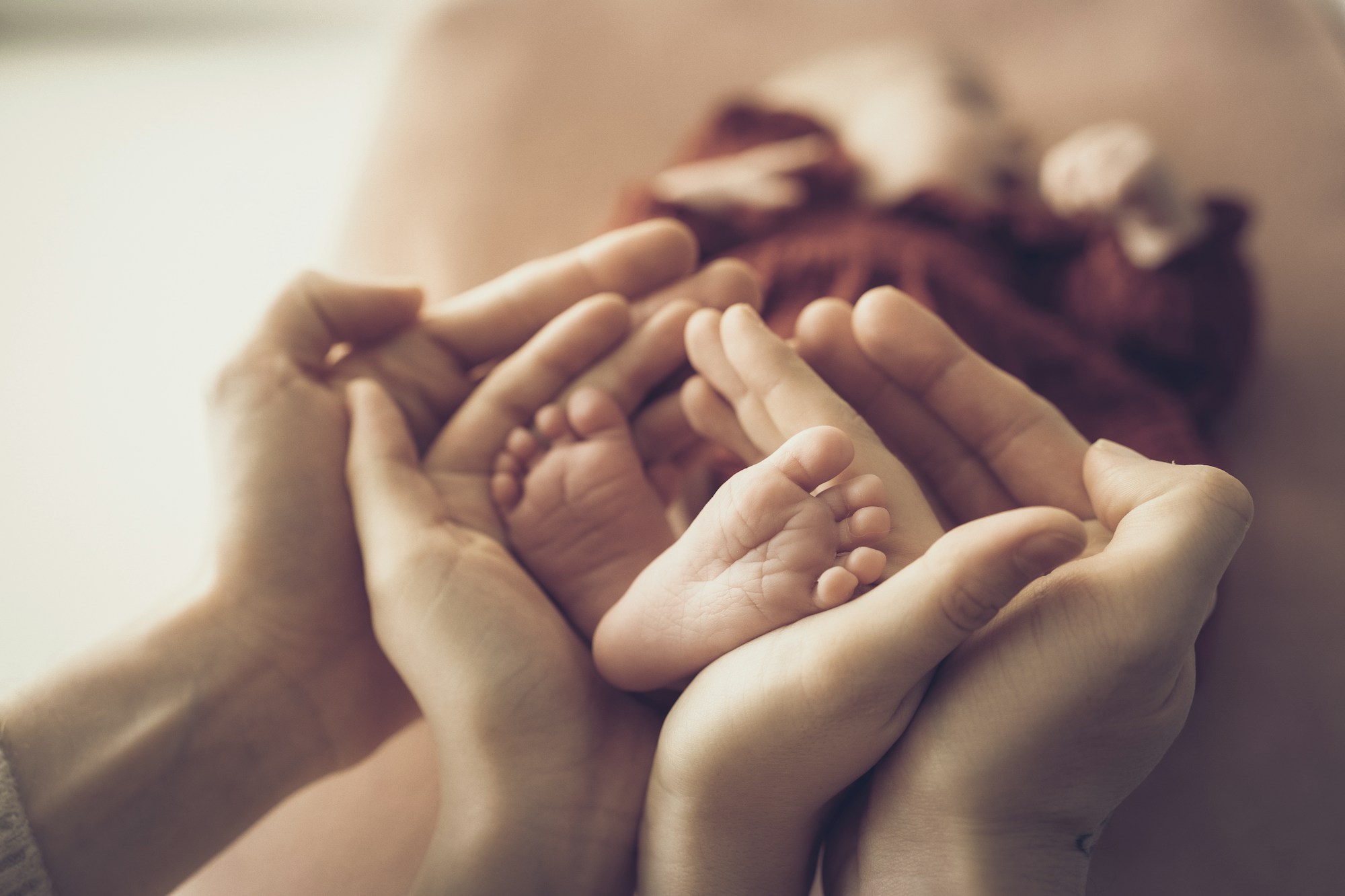Parents gently holding tiny newborn baby feet before making a footprint keepsake