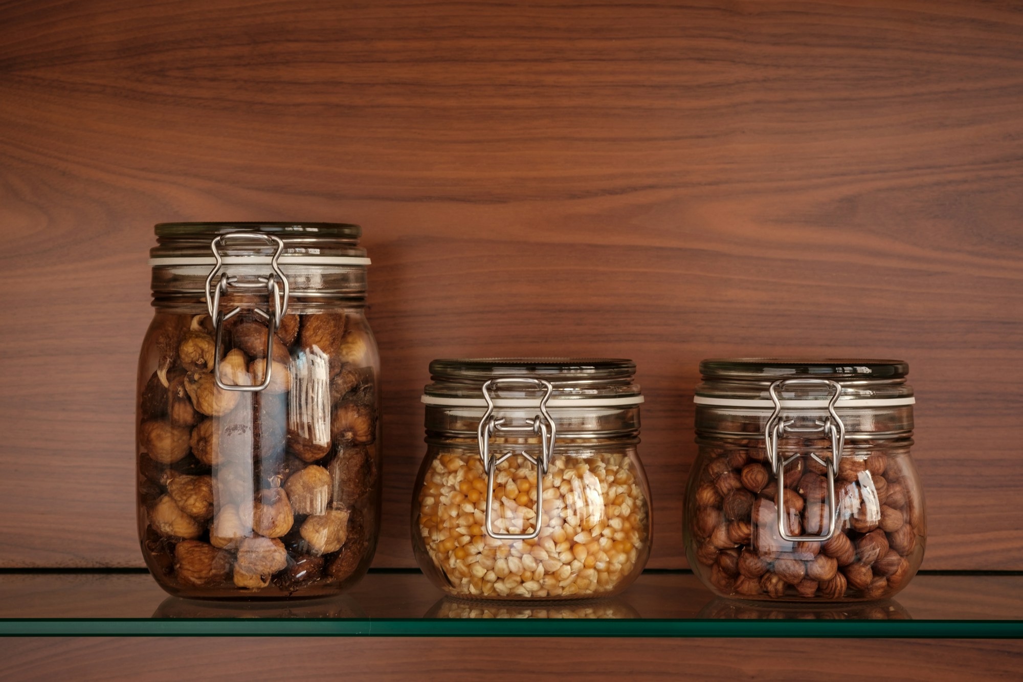 Glass jar of spiced nuts with a fabric cover and twine
