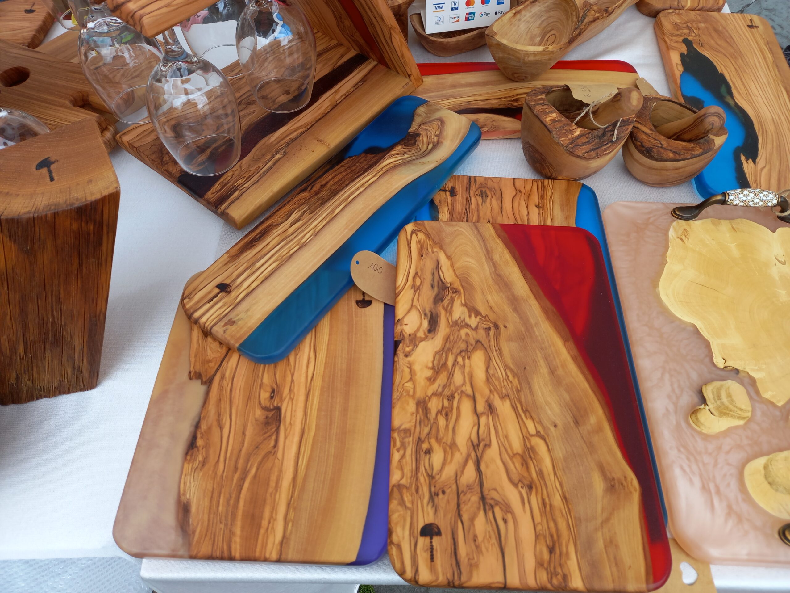 Olive wood serving boards with colorful epoxy resin rivers at a market stall
