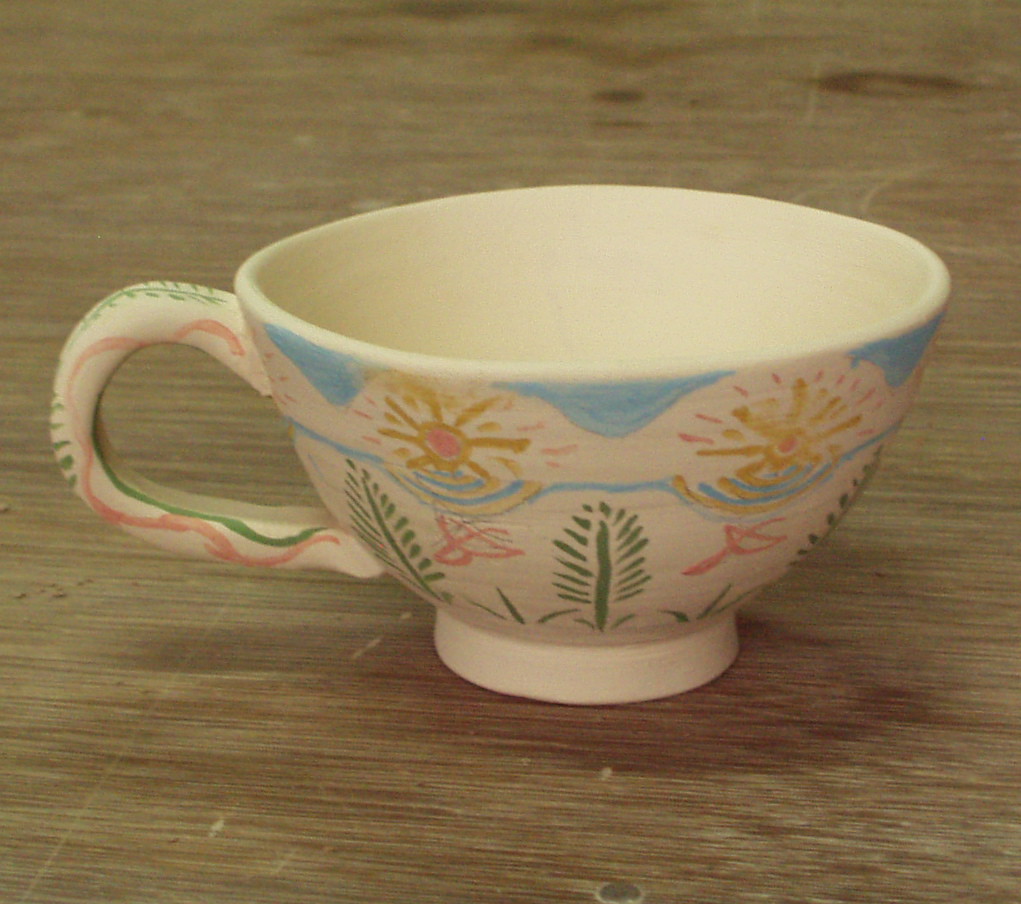 Hand painted ceramic cup with soft folk art suns, leaves and flowers