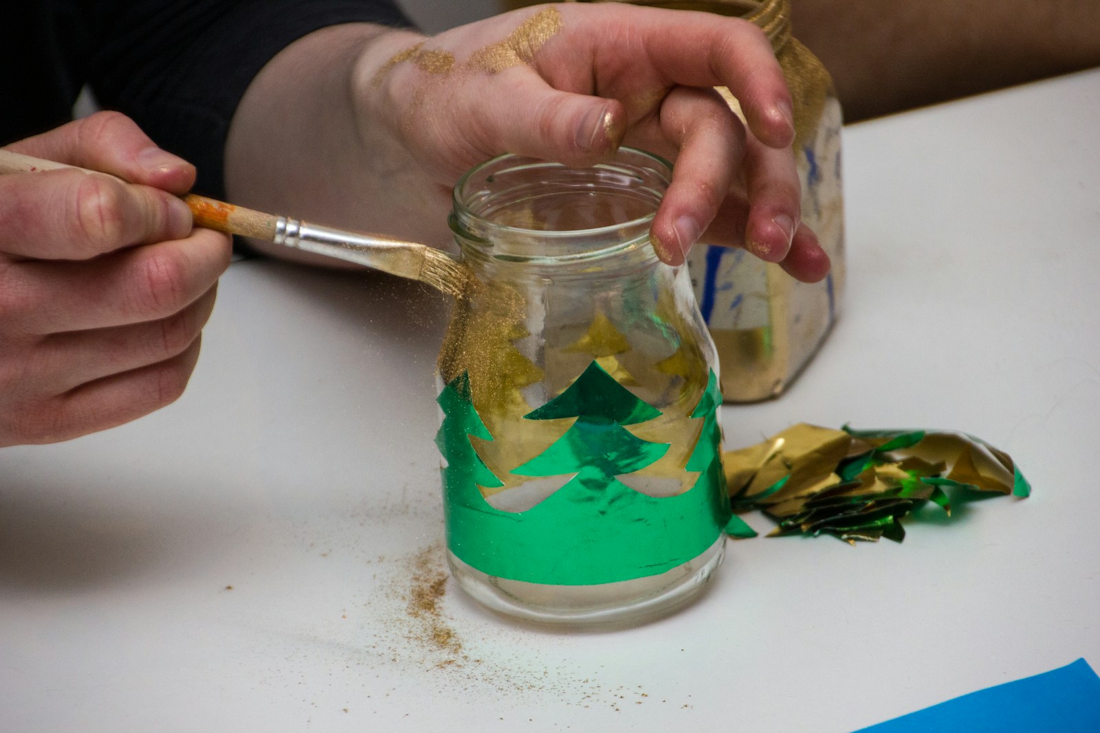 Painting a glass jar with a green tree design