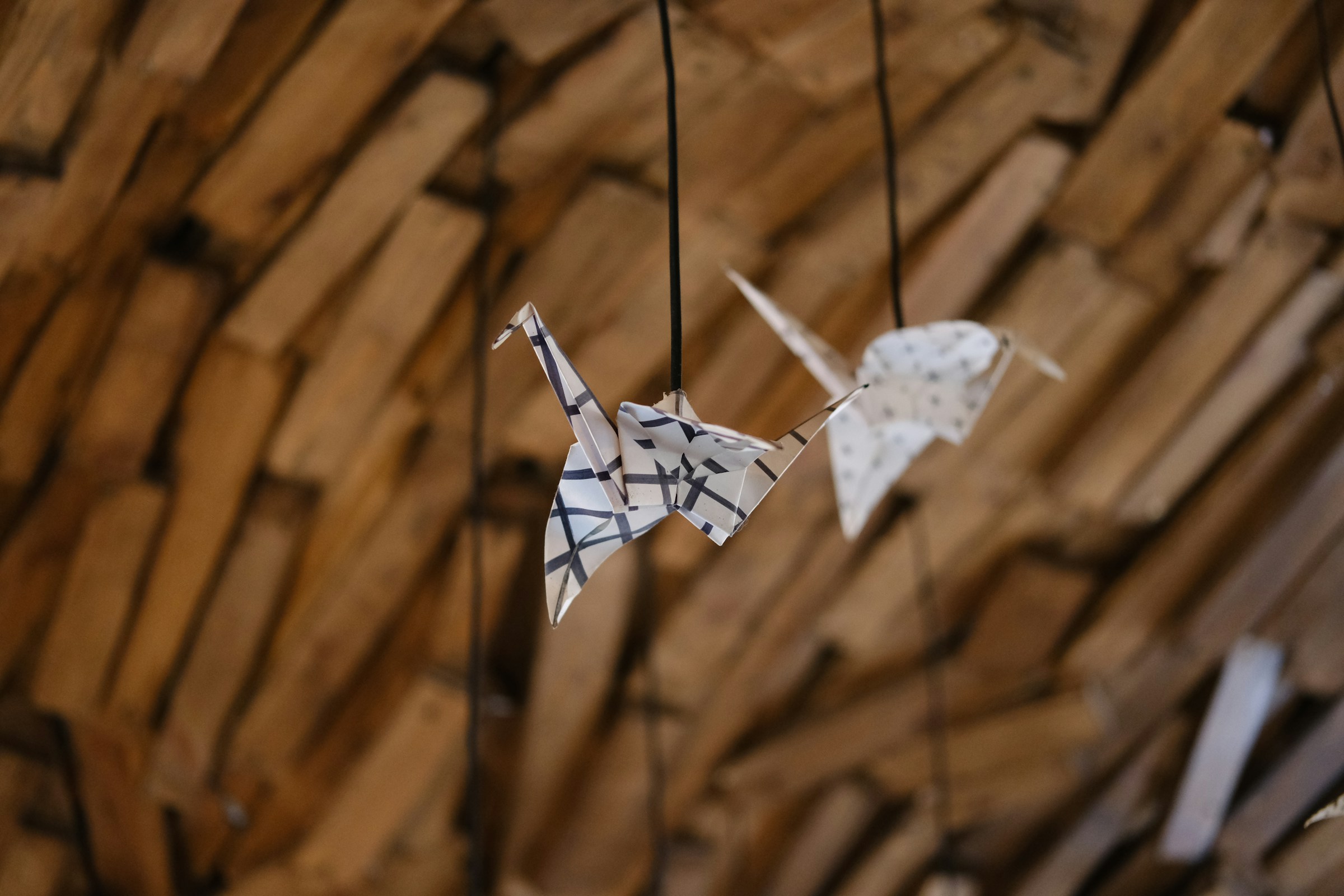 Folded paper origami birds hanging from strings as a mobile