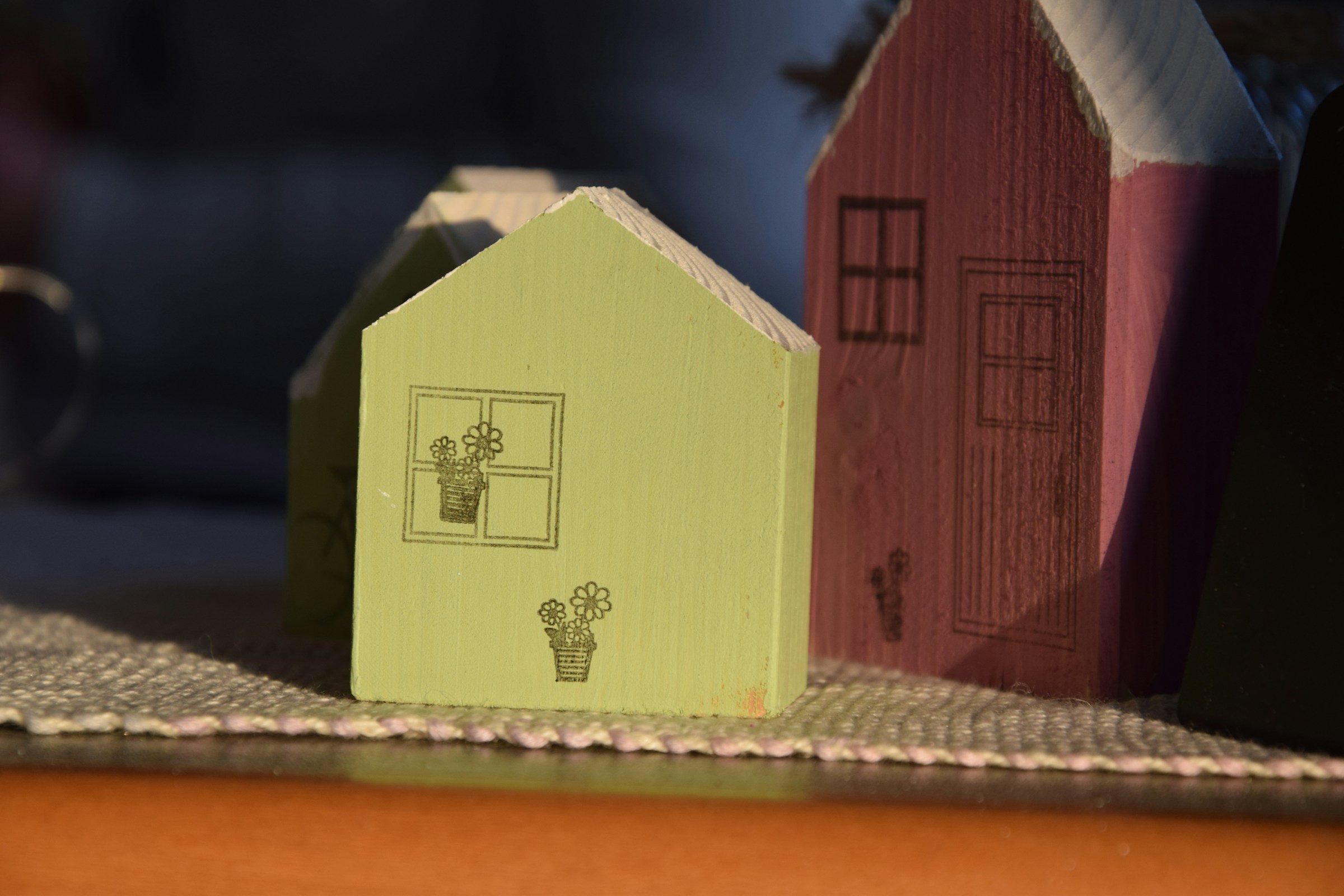 A little village of small handmade painted houses on a table