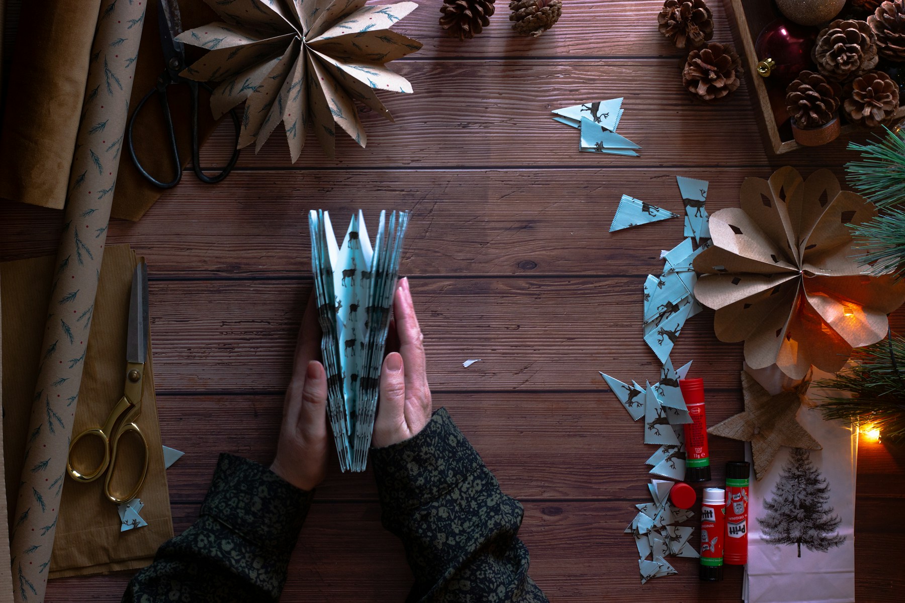 Folded paper star ornament held in hand, recycled Christmas decorations idea
