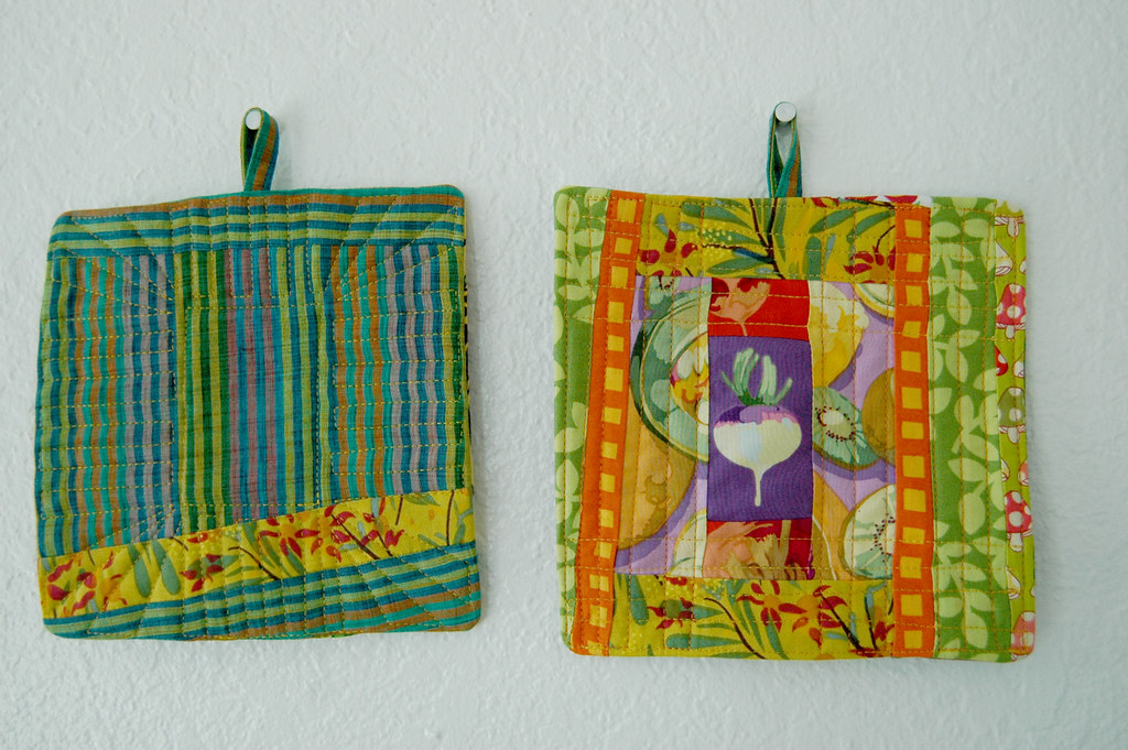 Laura Ingalls Wilder style patchwork pot holders hanging on a wall