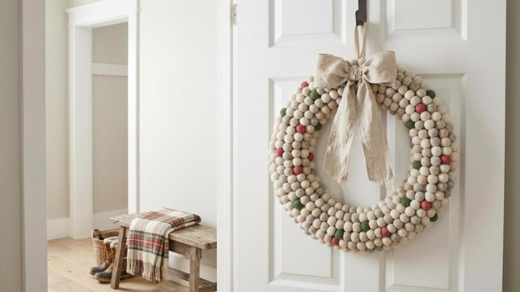 Pottery Barn Christmas Dupes felt ball wreath with a linen bow on a white door