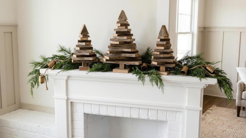 Three stacked scrap wood Christmas trees in different heights on a mantel
