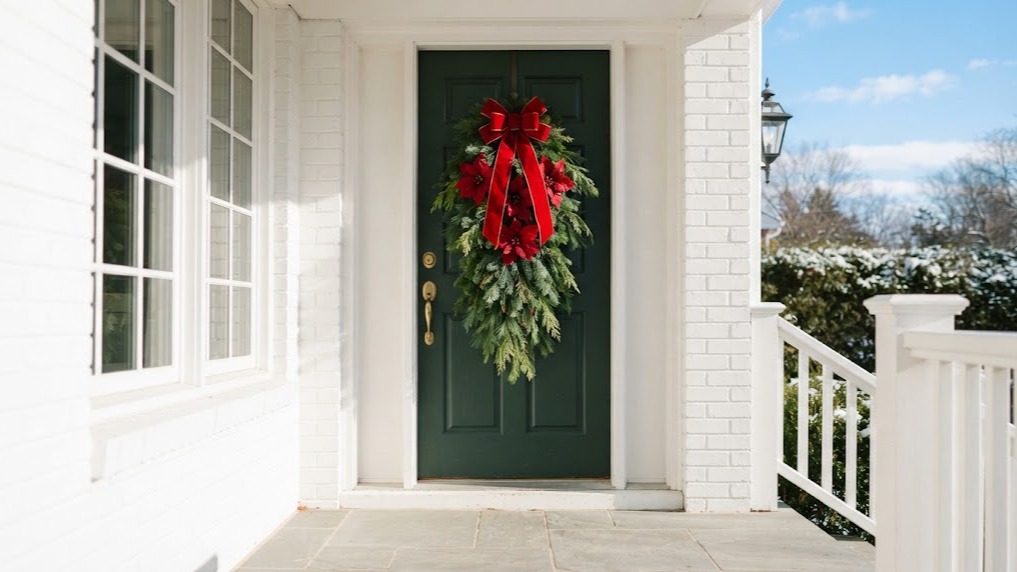 Poinsettia Christmas decor door swag with a red velvet bow