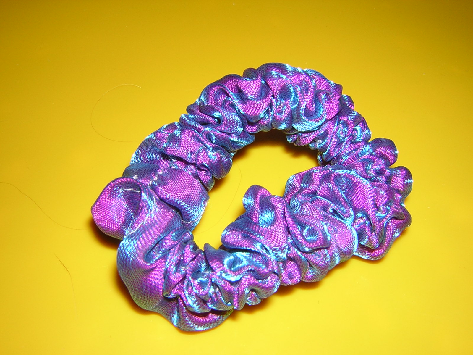 Colorful fabric scrunchie on a yellow background