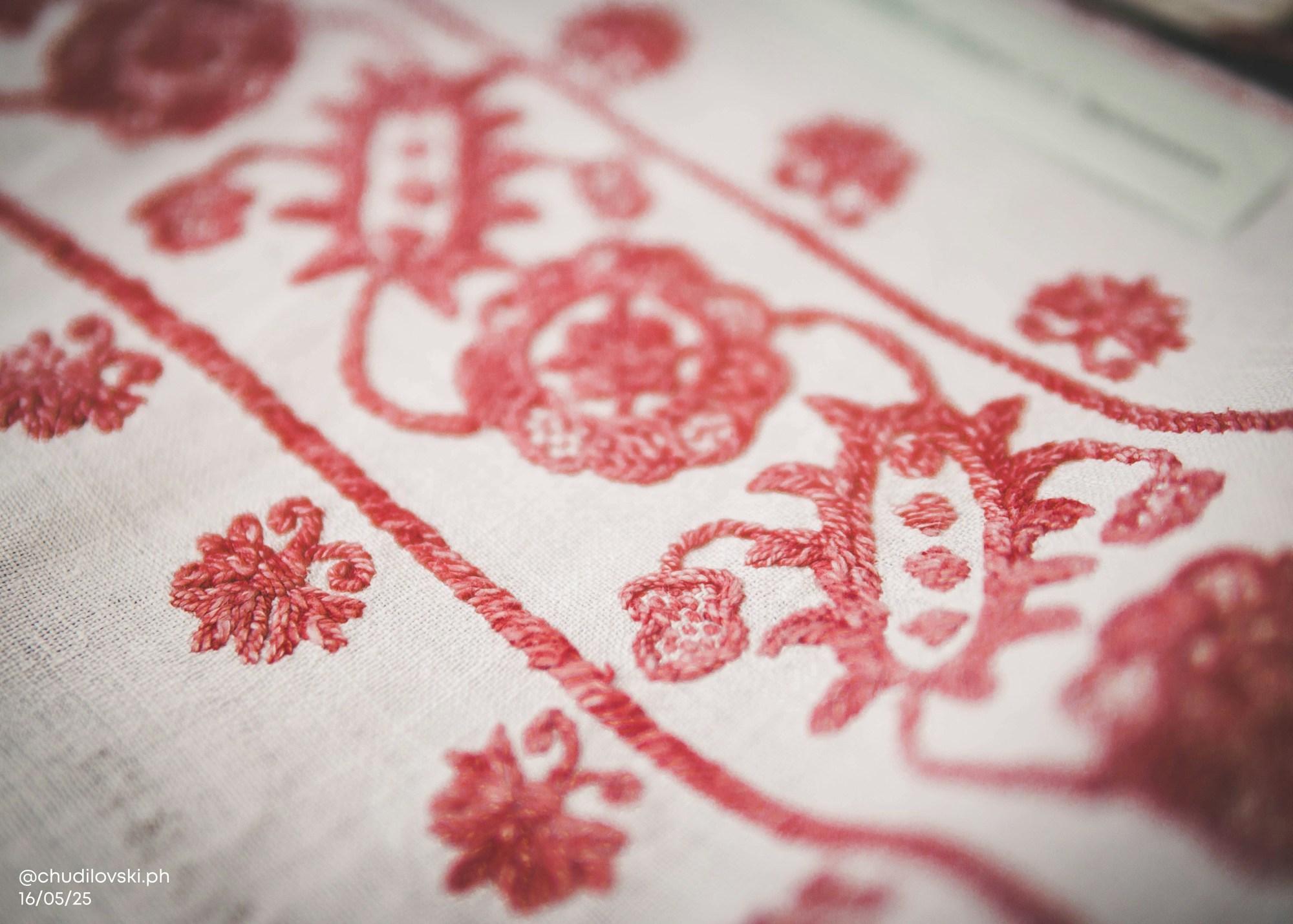Red floral embroidery stitched on white cloth for napkins
