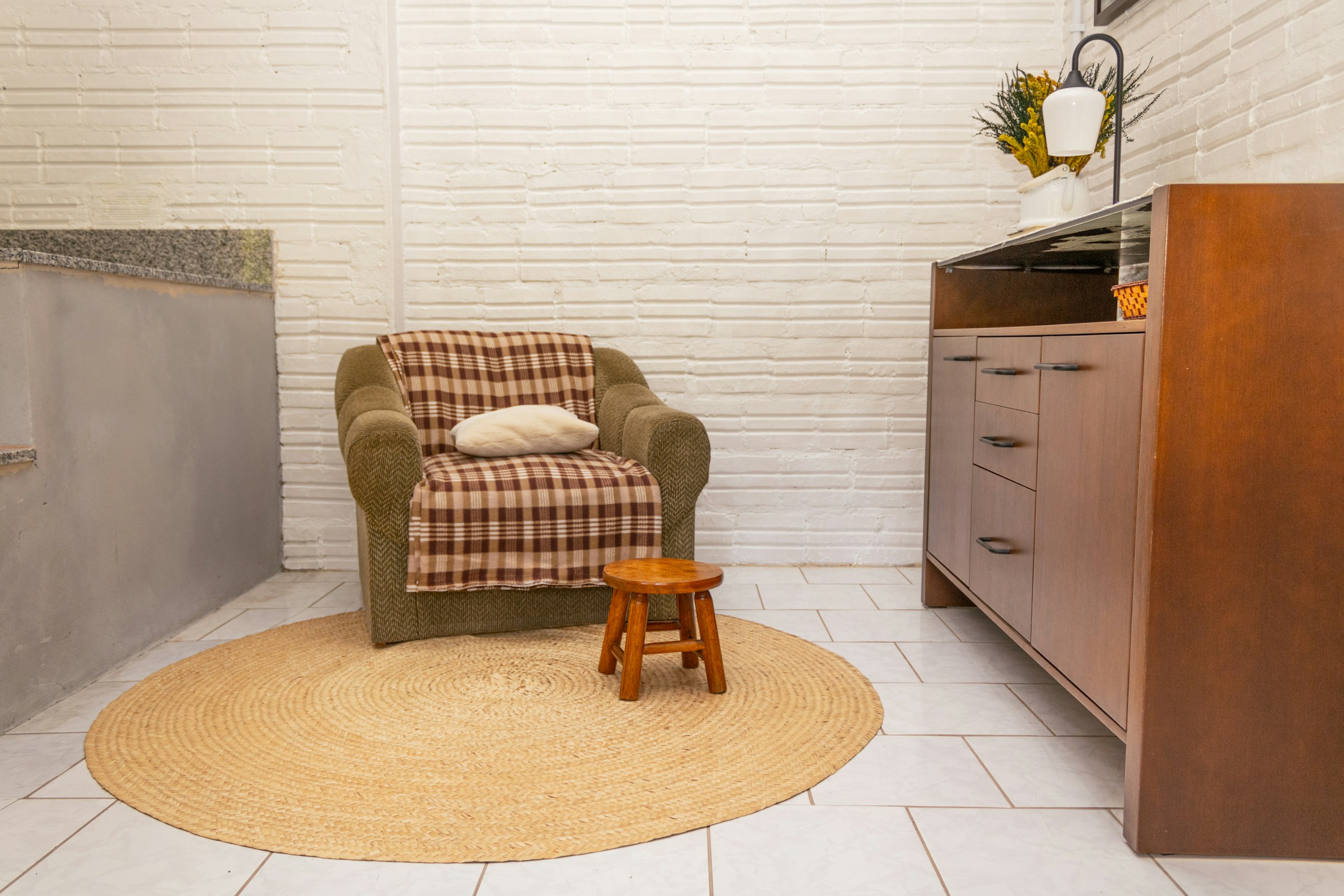 Renter friendly upgrades: round jute rug covering a tile floor under an armchair