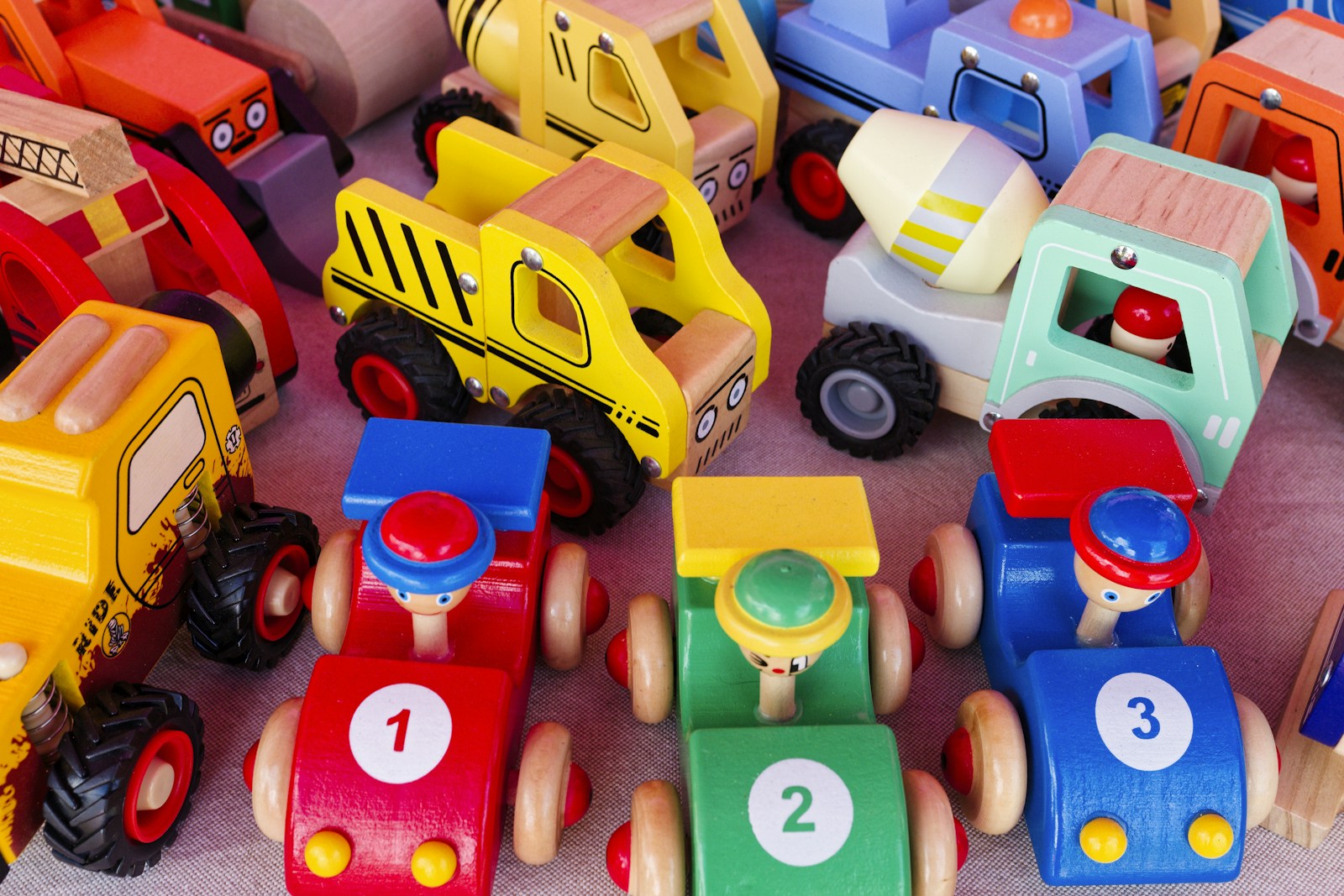 Pile of colorful wooden toy cars and trucks on a table