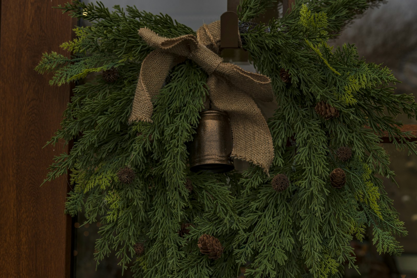 Rustic Christmas wreath with pine cones and a bell