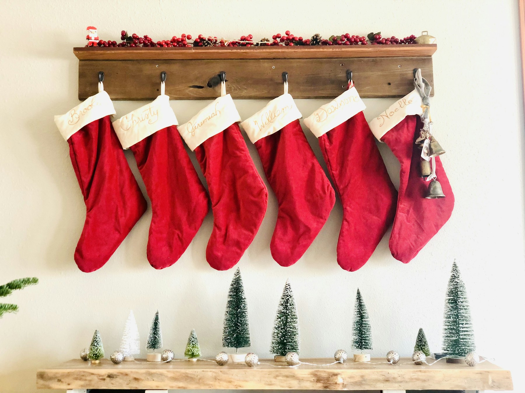Row of handmade Christmas stockings hanging from a wooden shelf