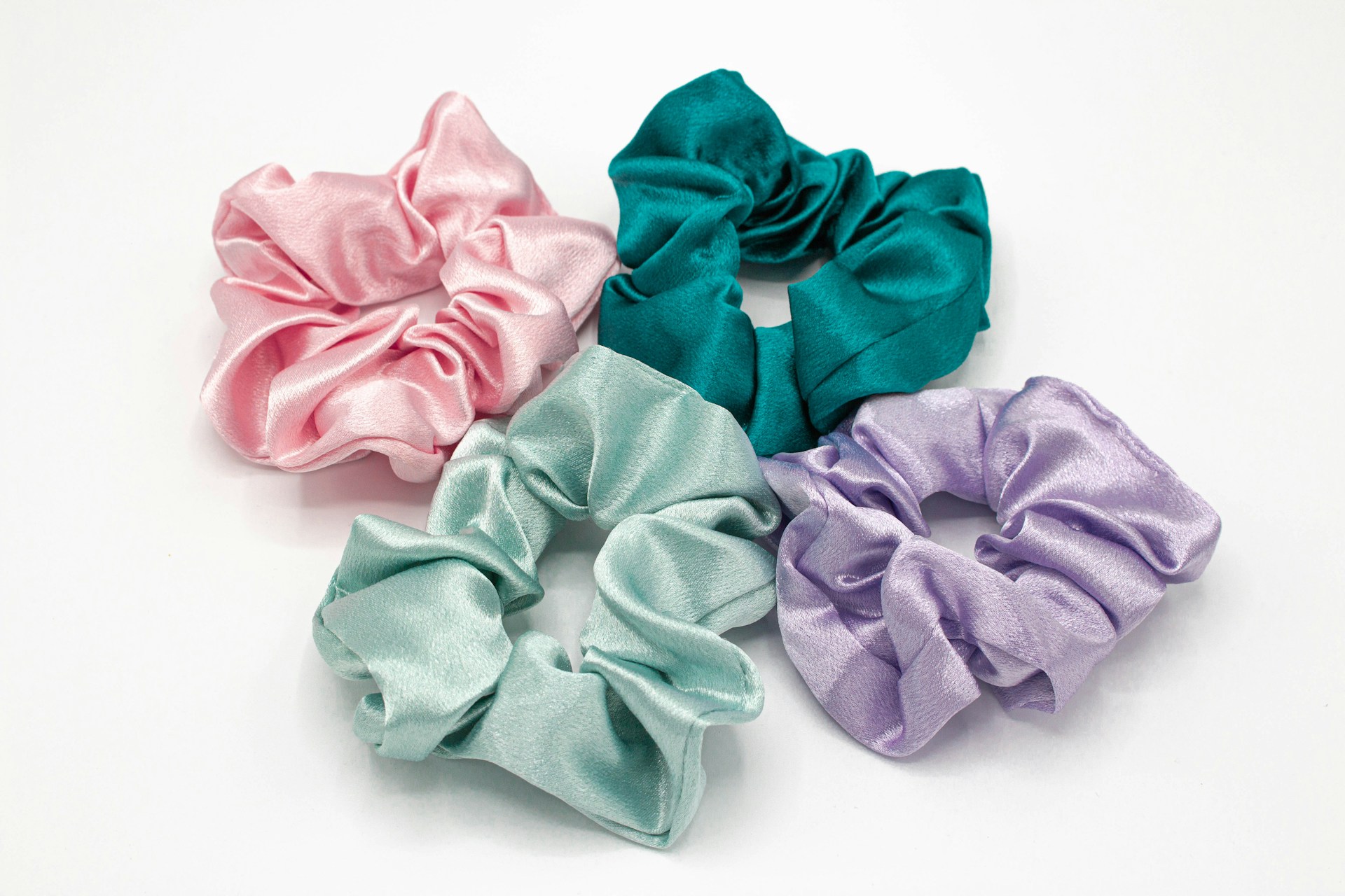 Four handmade satin scrunchies in pink, teal, mint and lilac
