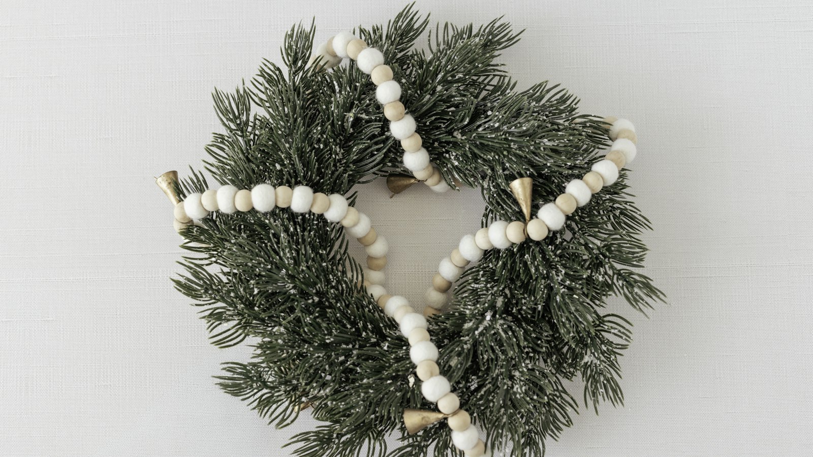 Scandinavian Christmas decor: natural wooden bead garland draped over a small evergreen wreath