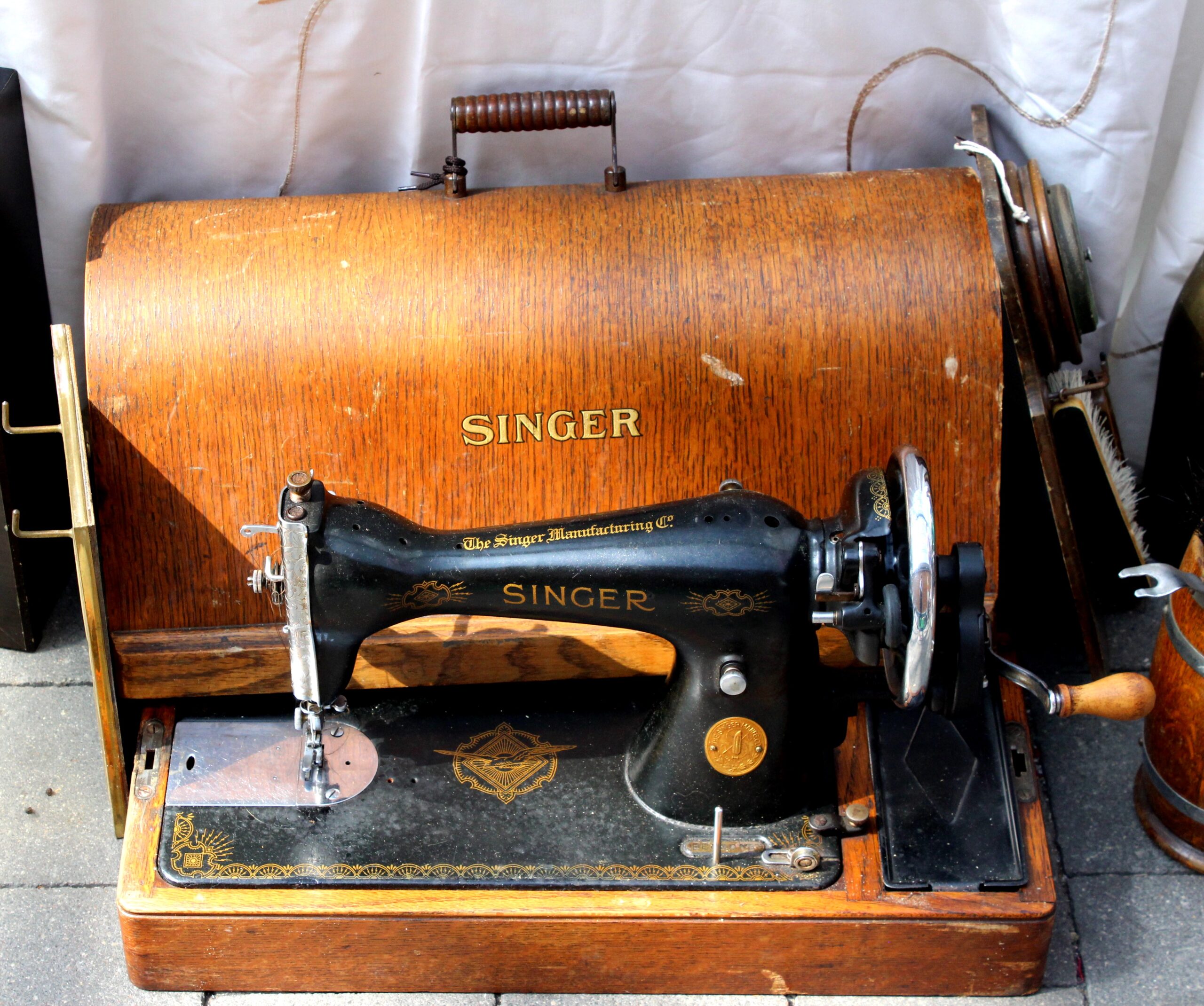 Vintage black sewing machine with a wooden case for sale at a flea market
