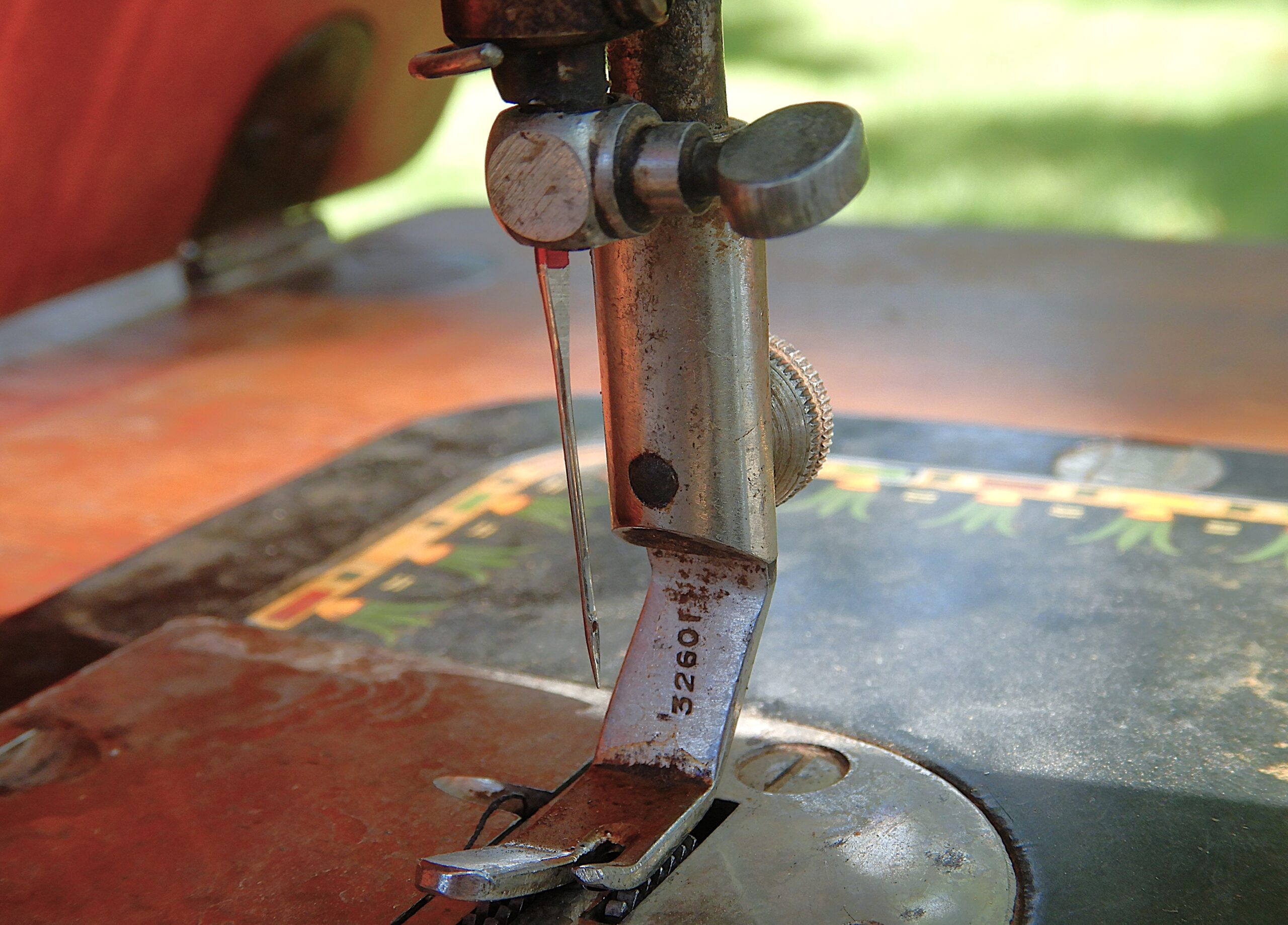 Close up of the needle and presser foot of an antique sewing machine