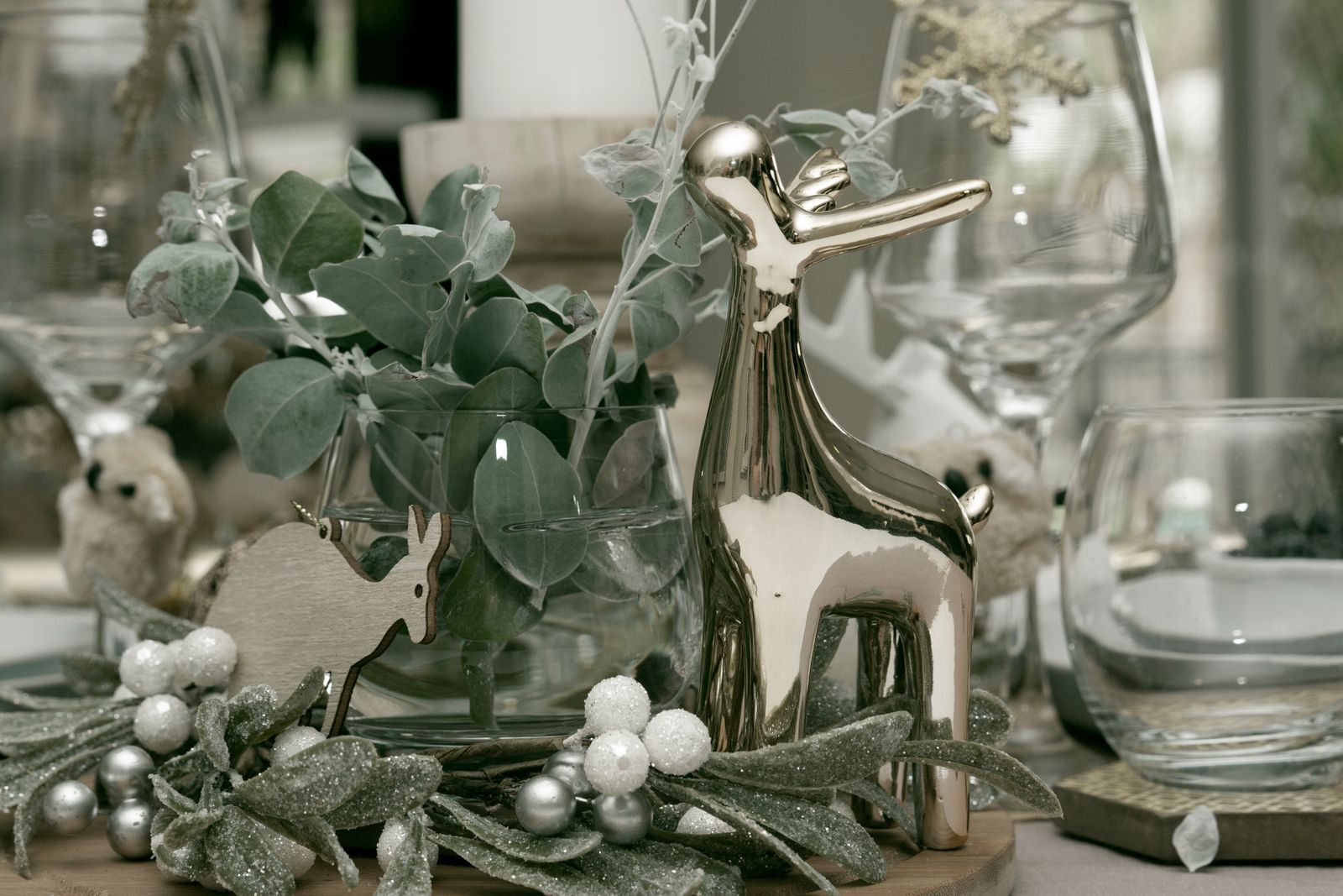 A winter table set with a silver deer, eucalyptus and small silver ornaments