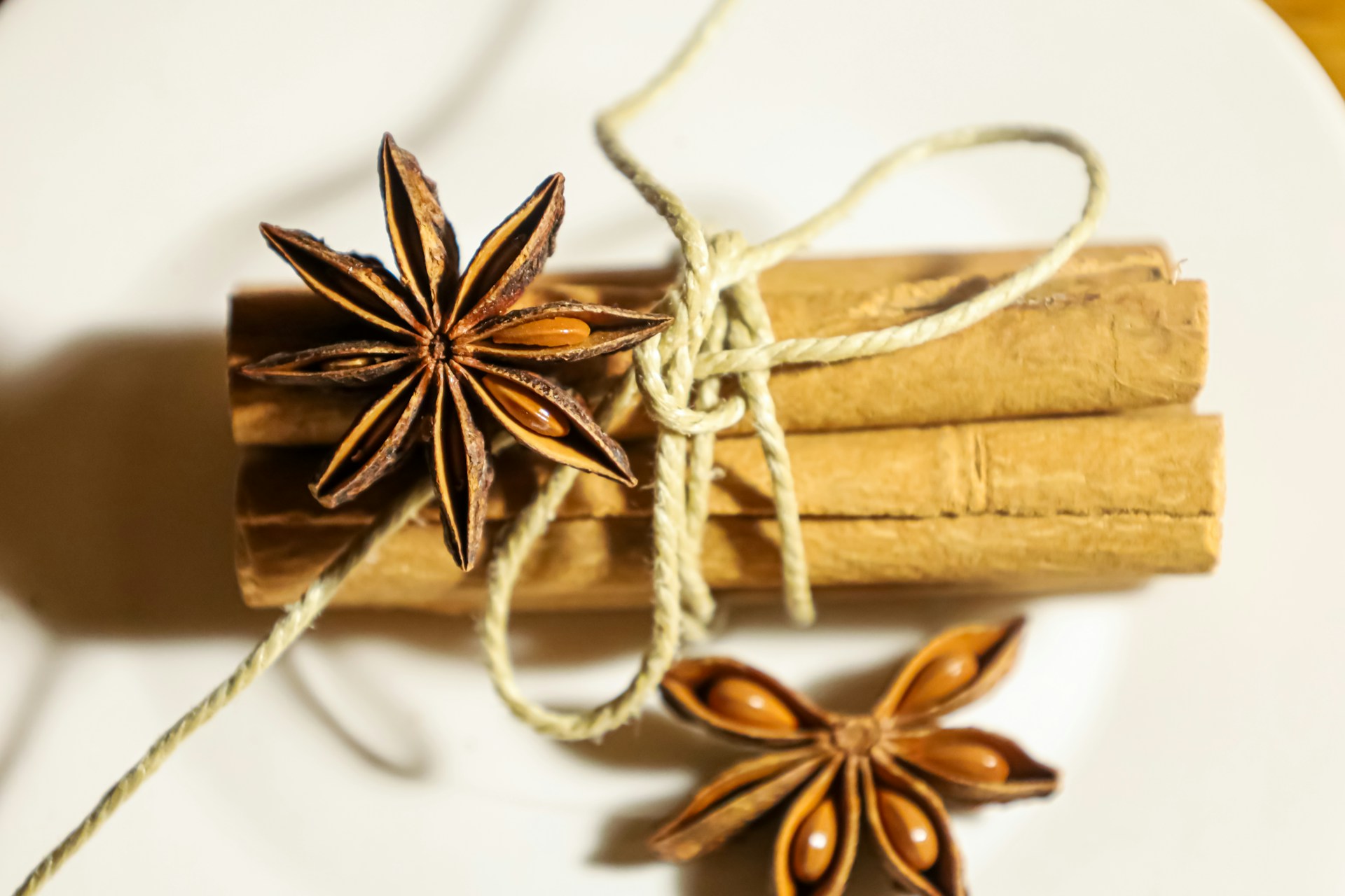 DIY simmer pot gifts idea, a bundle of cinnamon sticks tied with twine beside star anise