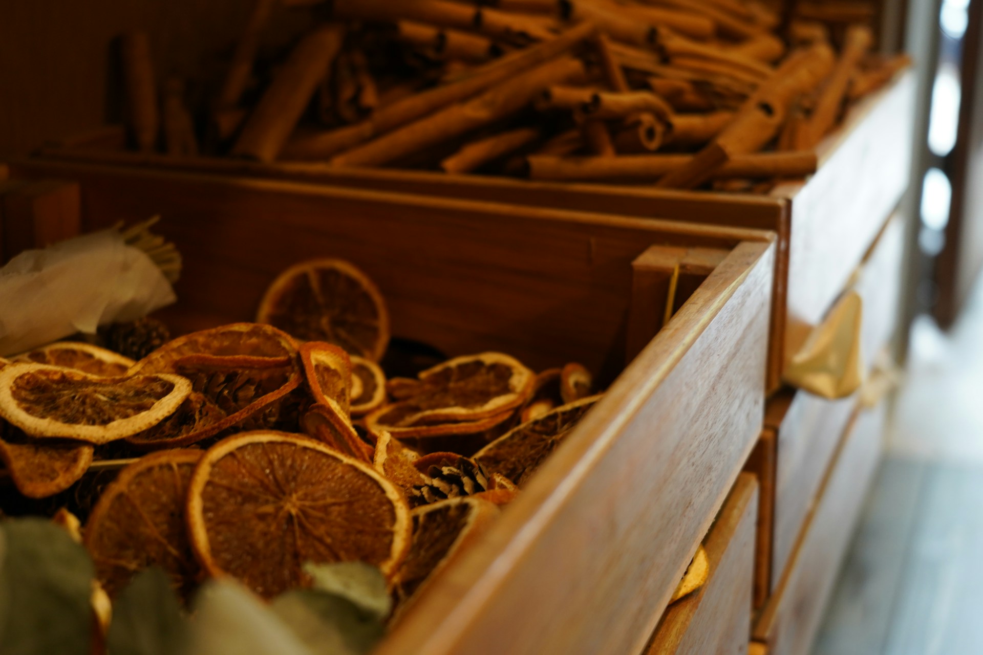 Dried orange slices and cinnamon sticks in a wooden bowl