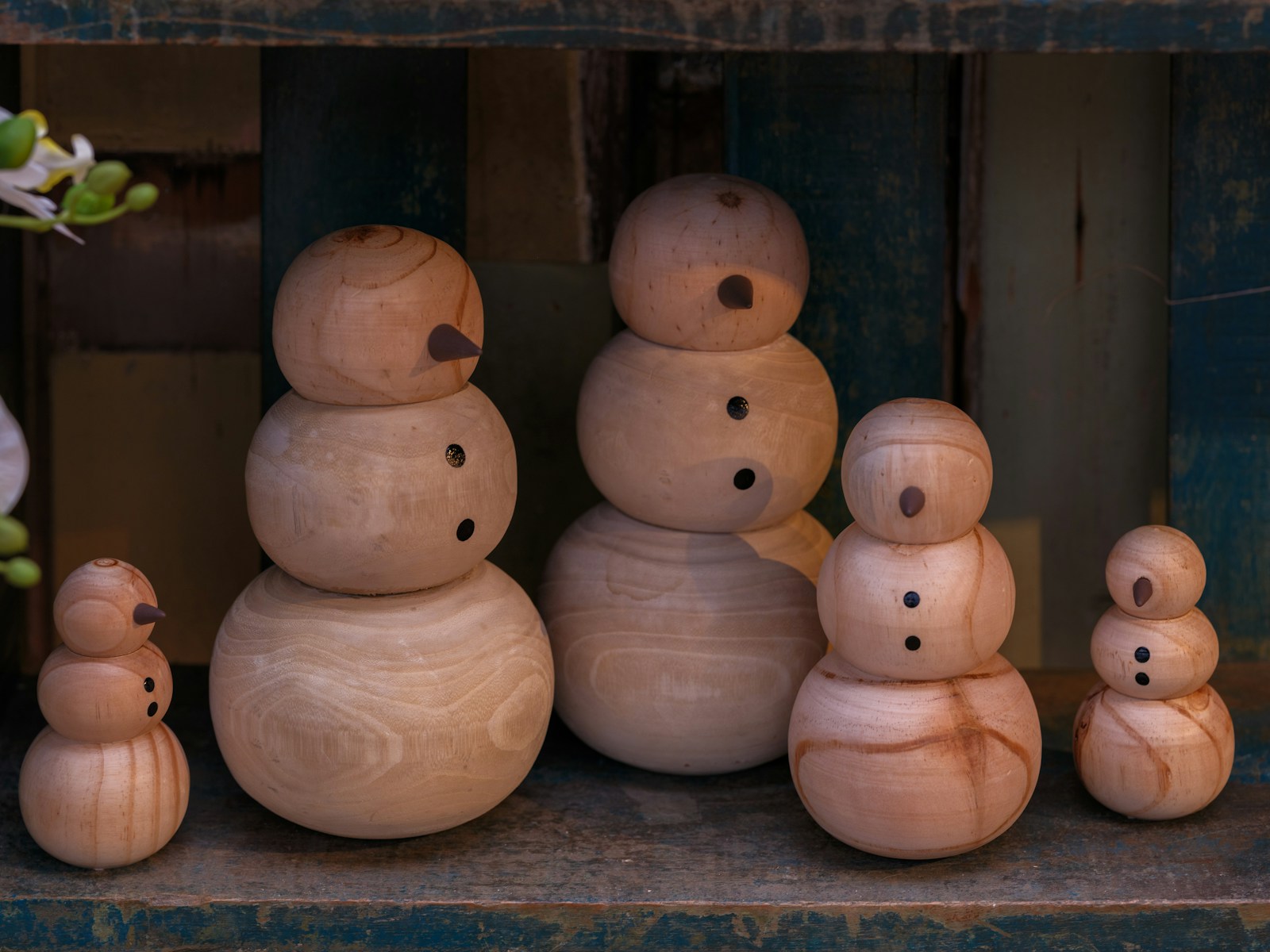 Carved wooden snowmen in different sizes lined up together