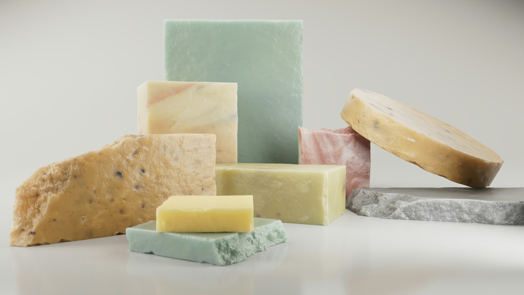 Stack of natural cream and green handmade soap bars of different shapes