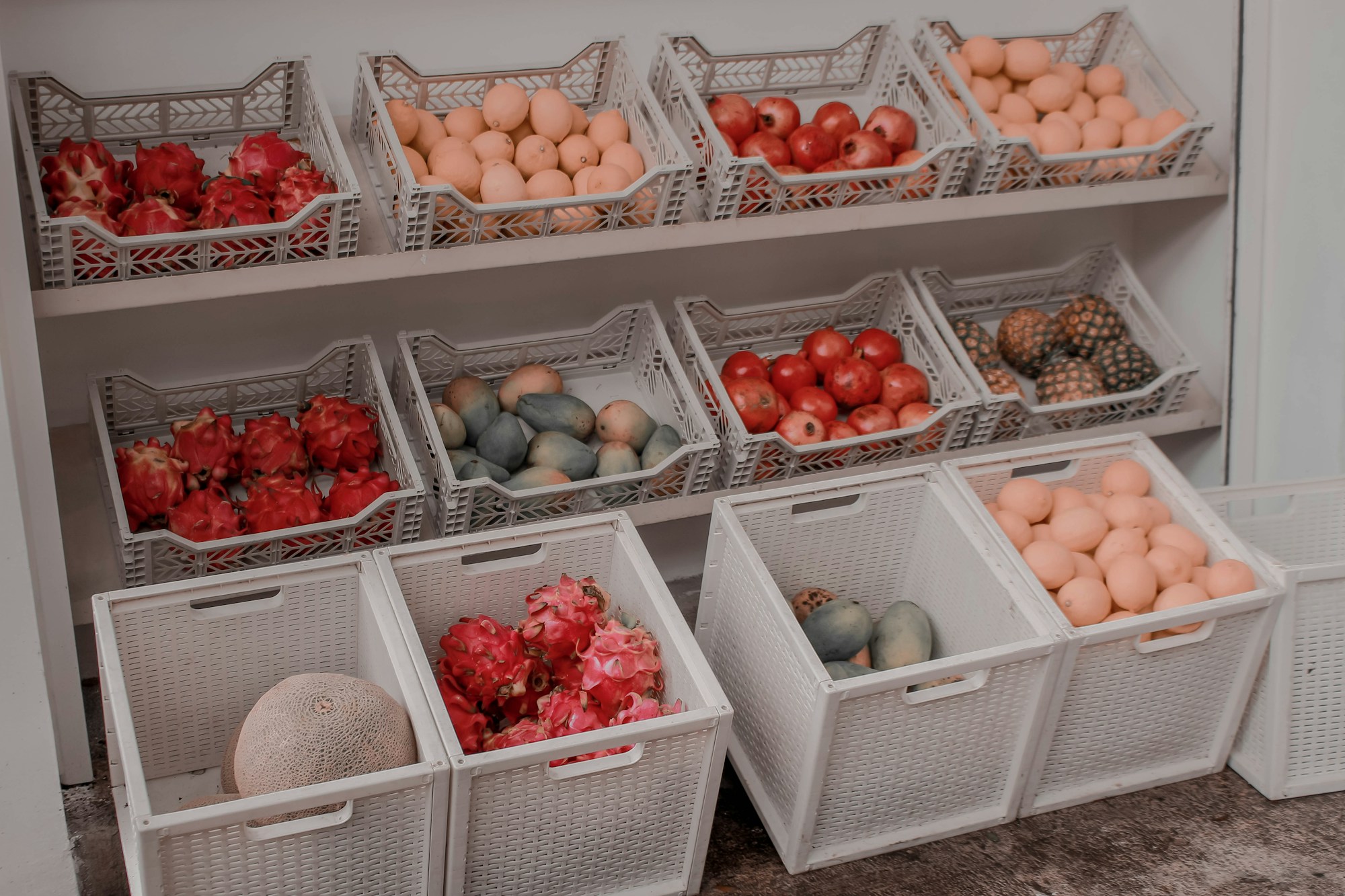 Stackable white bins holding apples, onions and potatoes
